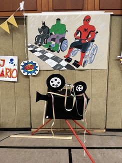 Dekoration für Karneval: ein gemaltes Bild von drei Superhelden im Rollstuhl.